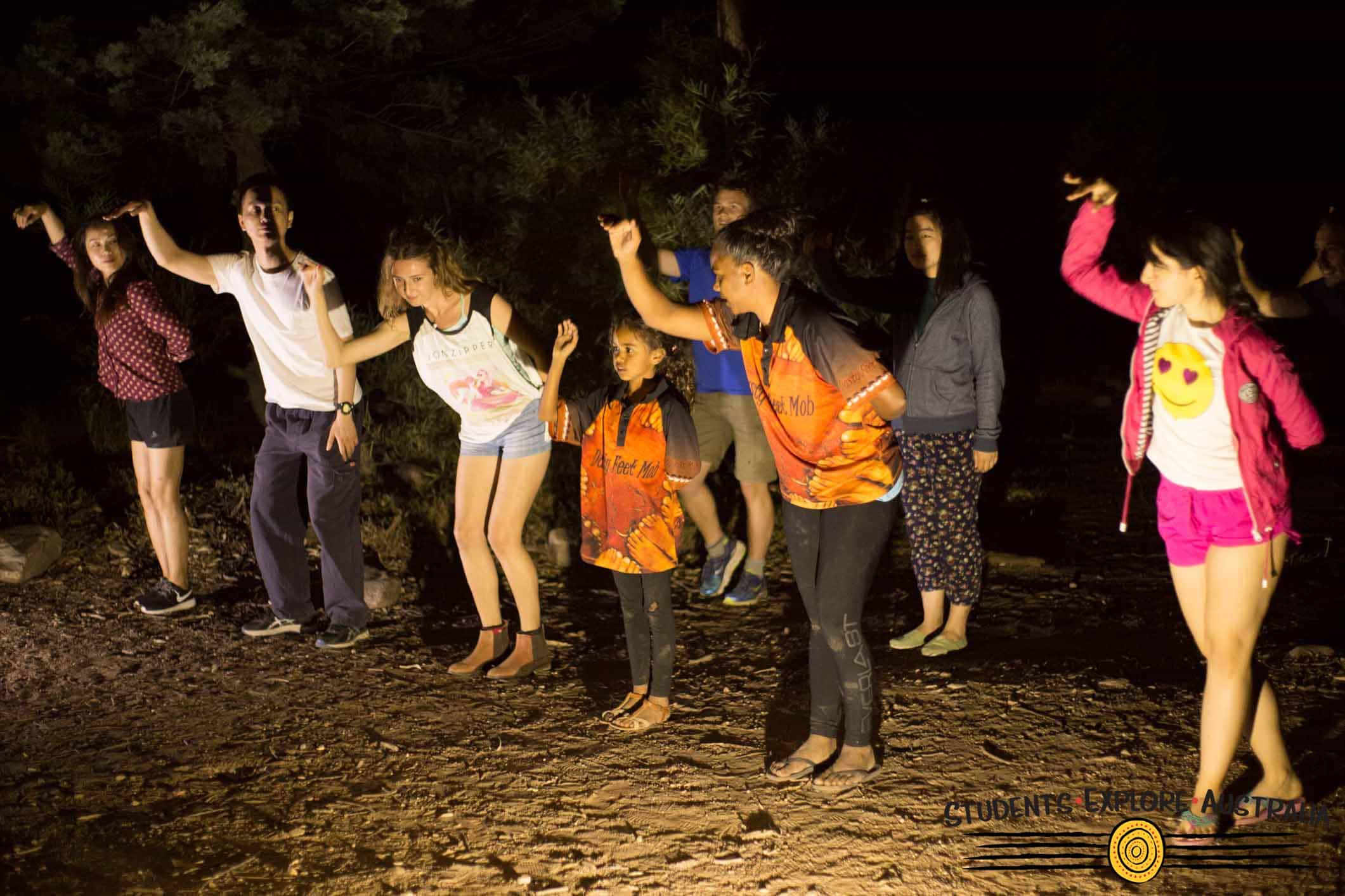 Children practicing aboriginal dance at night