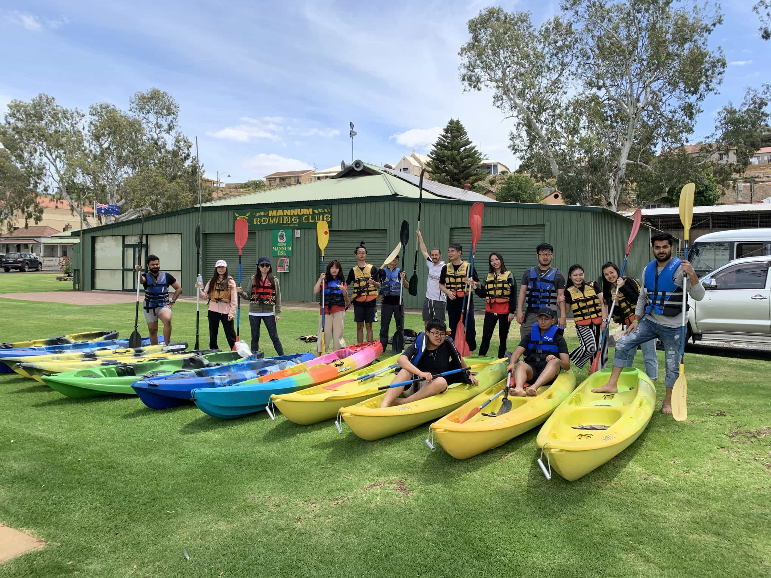 Students with kayaks on the grass