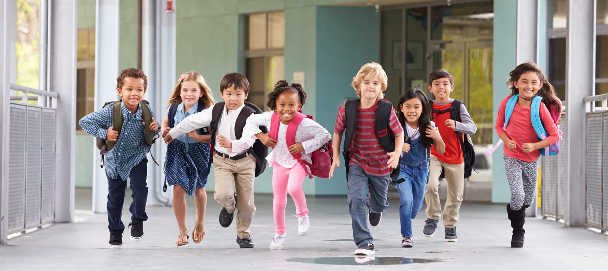 Primary school children running in the hallways at hometime holding hands