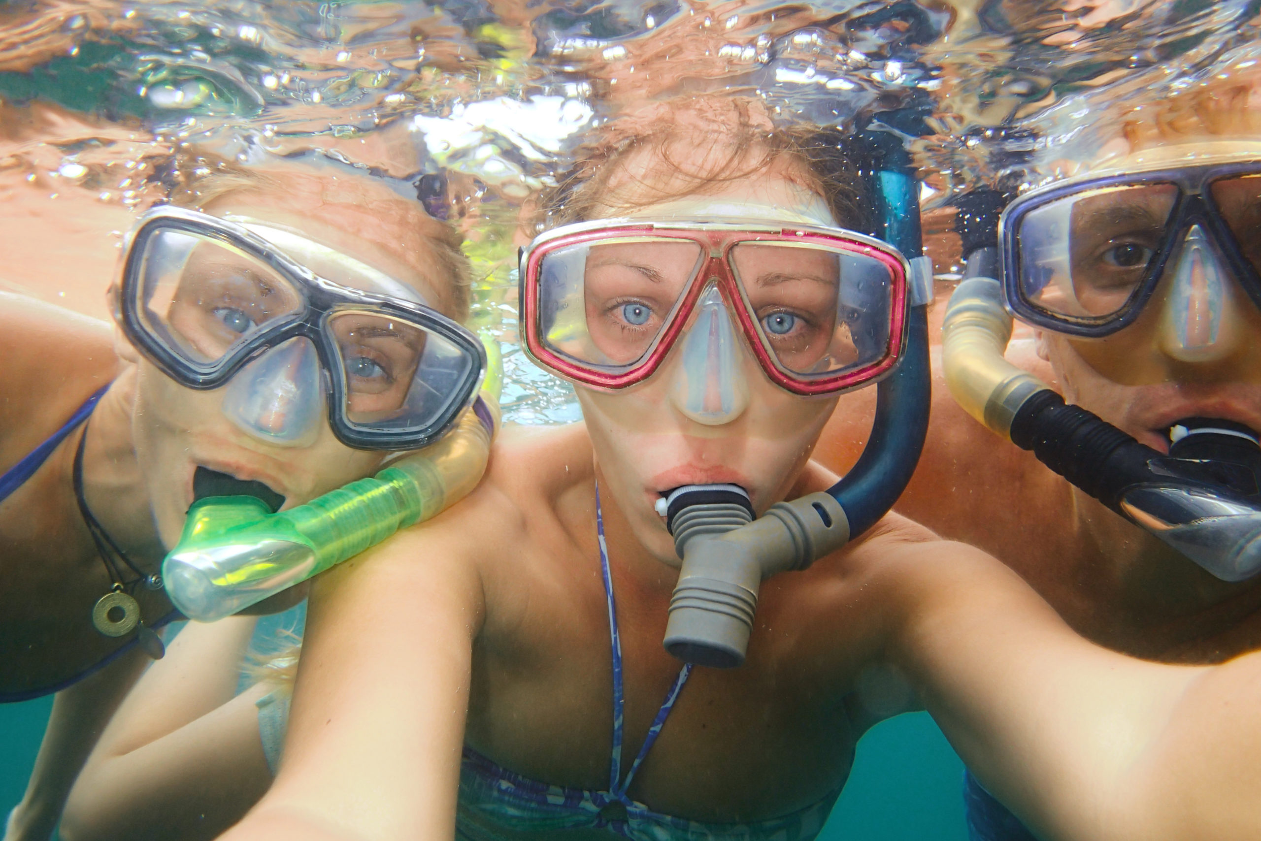 Underwater photo of a young people snorkeling at tropical ocean.