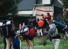 Students with camping backpacks walking